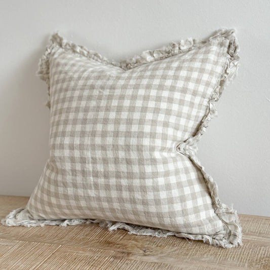 Ellenvale Ruffled Edged Linen Cushion Cover in Natural Gingham displayed on a bench against a white wall.