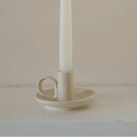 Cream candle holder called 'wee willy winky' displayed with a white candle inside on a white and cream background