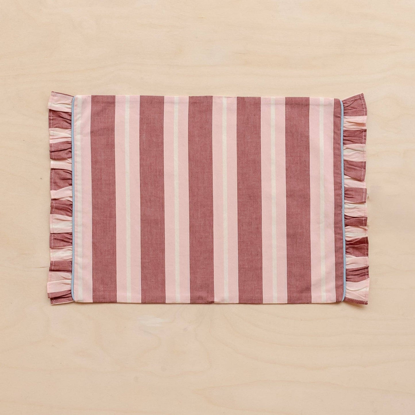 TBCo Cotton Placemats in Red and Pink Stripe with Frilly Edge laid flat on a pink background.