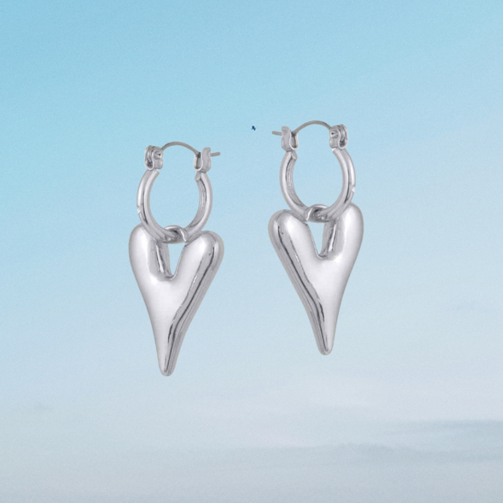 Silver heart-shaped hoop earrings on a light blue background