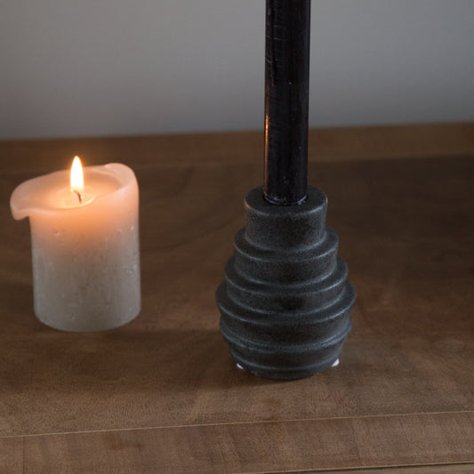 bloomingville black stoneware candle holder with black candle displayed inside