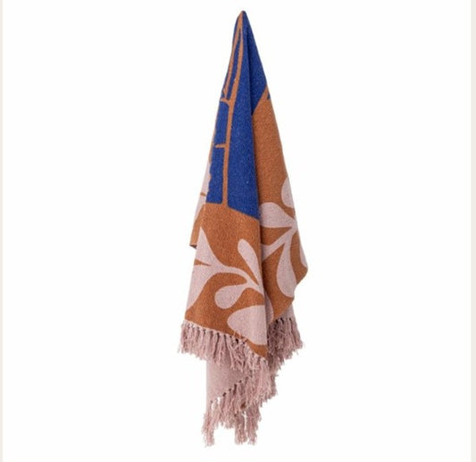 Throw with floral pattern and fringes on a white background