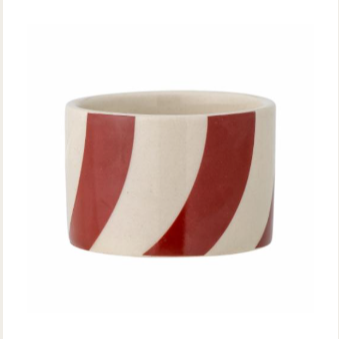 A cylindrical stoneware candle holder with bright red and white stripes.