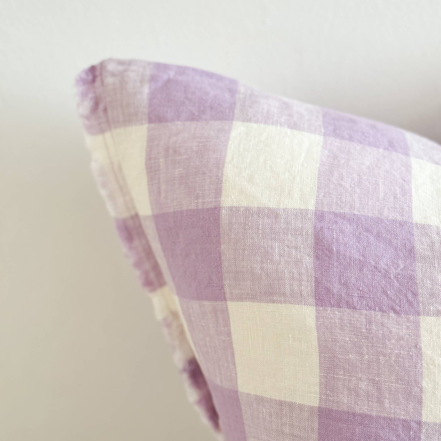 Close-up of a purple and white checkered fabric with a plain background