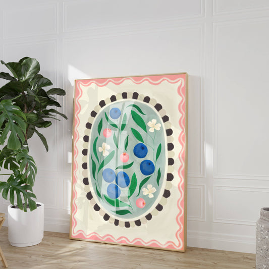 Decorative wall art with floral and blueberry design in a room with a plant and vase.