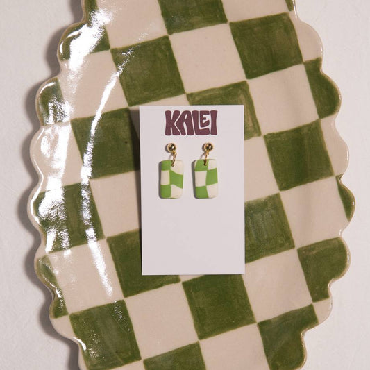 Green and white checkered earrings on a matching card with 'Kalei' branding, displayed on a green and white checkered stand.