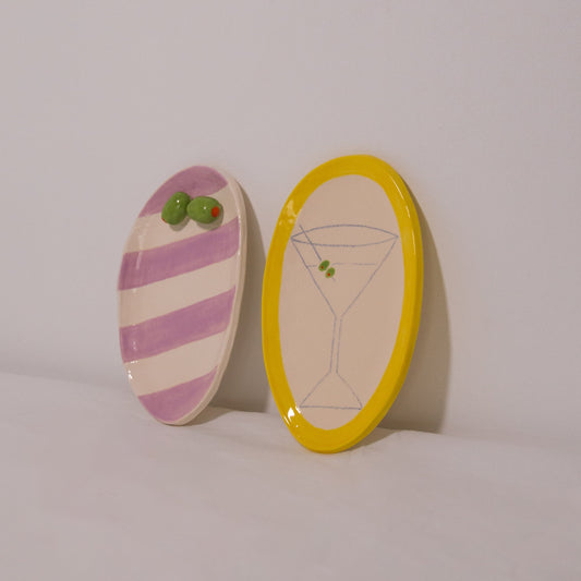 Two decorative oval plates with unique designs on a plain background