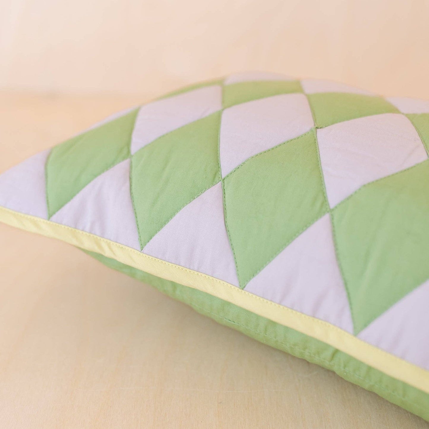 Close up of the Green argyle cushion on its side.