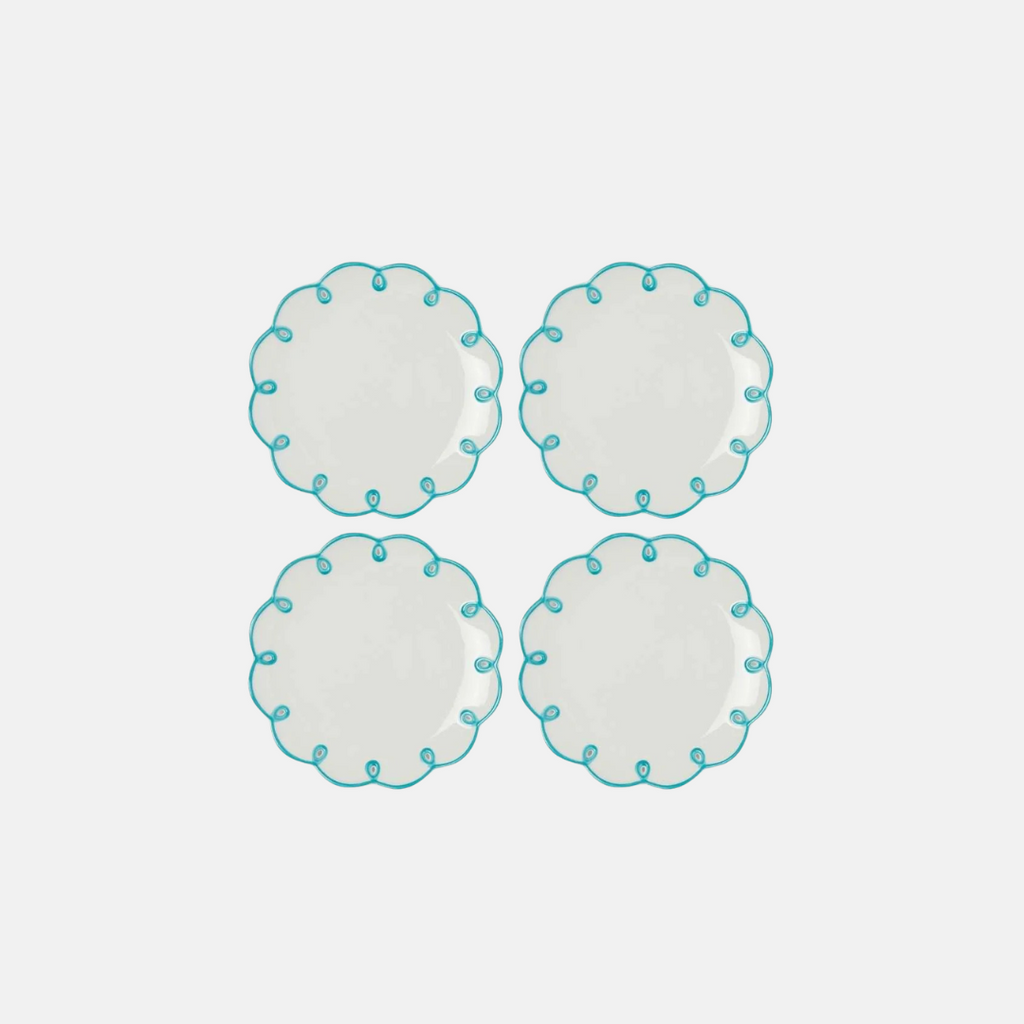 Four round ceramic plates with turquoise rim on a white background