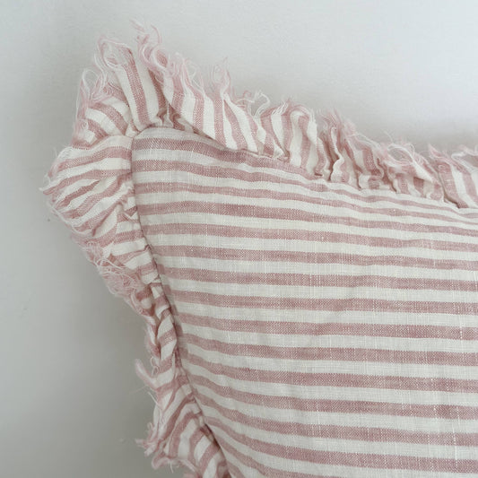 Close-up of a pink and white striped fabric with ruffled edge on a light background