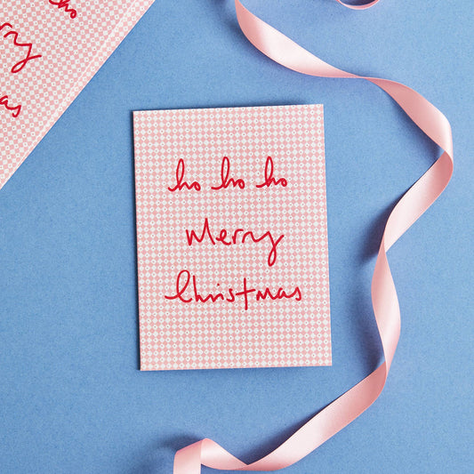 Christmas card with 'ho ho ho Merry Christmas' text on a blue background with a pink ribbon.