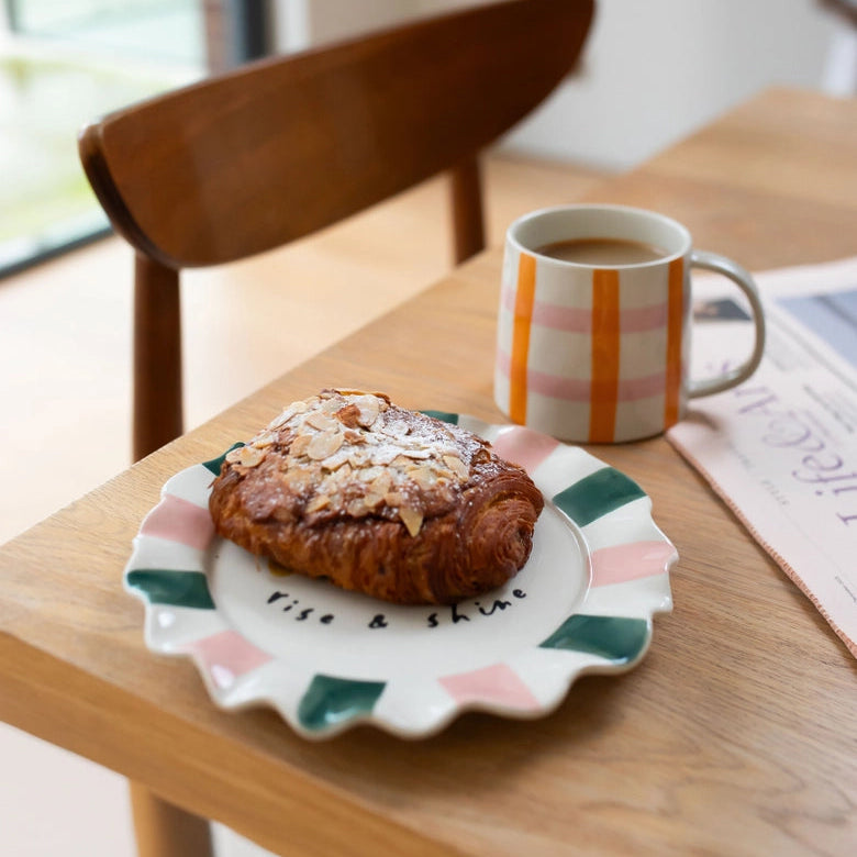Pastries on a plate with a mug of coffee on a wooden table