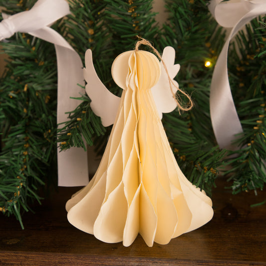 Decorative angel ornament on a Christmas tree with green branches and white ribbons.