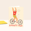 Card with illustration of a father on a bike and 'Badass Dad' text on a beige background