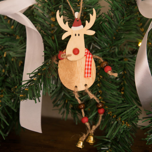 Wooden reindeer ornament with a Santa hat and red nose hanging on a Christmas tree.