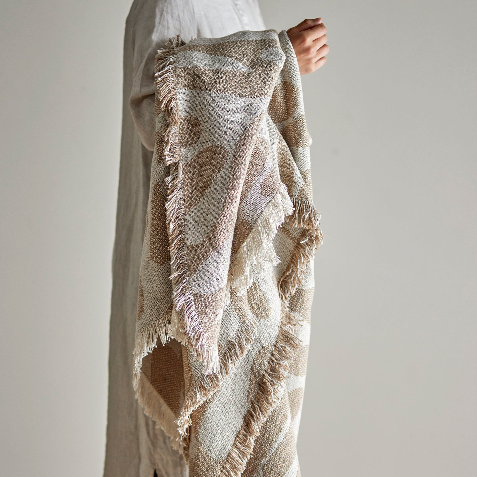 Bloomingville recycled cotton throw displayed by a female model holding the throw in her arm 