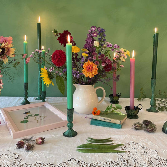 Styled colourful shot of Green 100% Iron Candle Holder Handmade in Northern India Rustic and cottage core aesthetic displayed with candles burning 