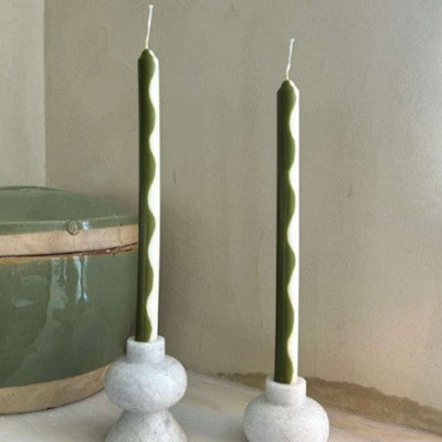 Pigmalion London Set of 2 Dinner Candles in Olive Green and Cream showcasing a wavy design from top to bottom.  displayed in two candle holders