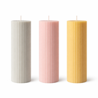 Three ribbed pillar candles in beige, pink, and orange colors, made from soy wax, displayed on a white surface against a neutral background.