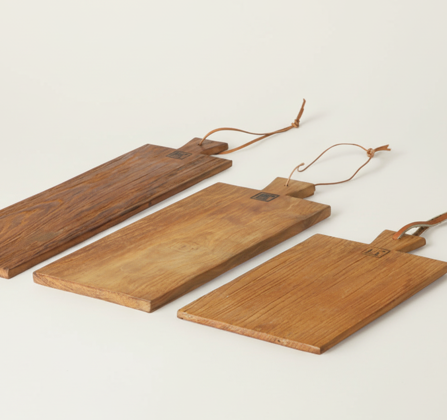 Three wooden cutting boards with handles on a light background