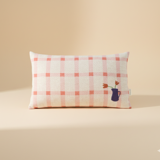 Checkered pillow with floral embroidery on a beige background