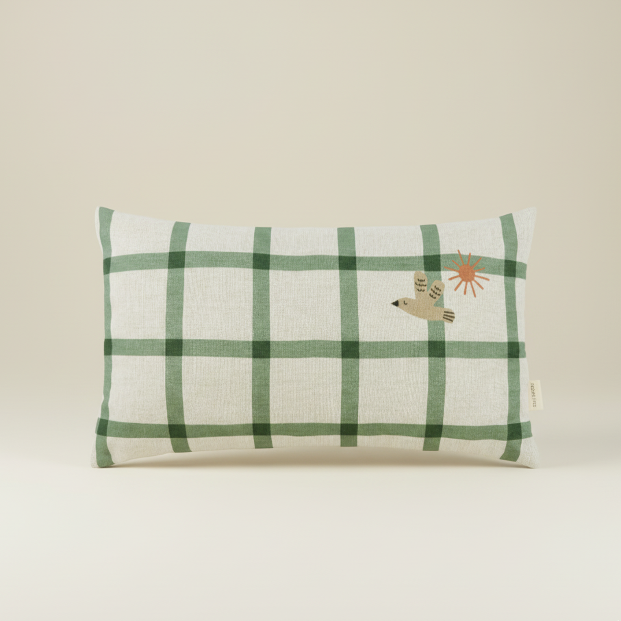 Green checkered pillow with a bird design on a beige background