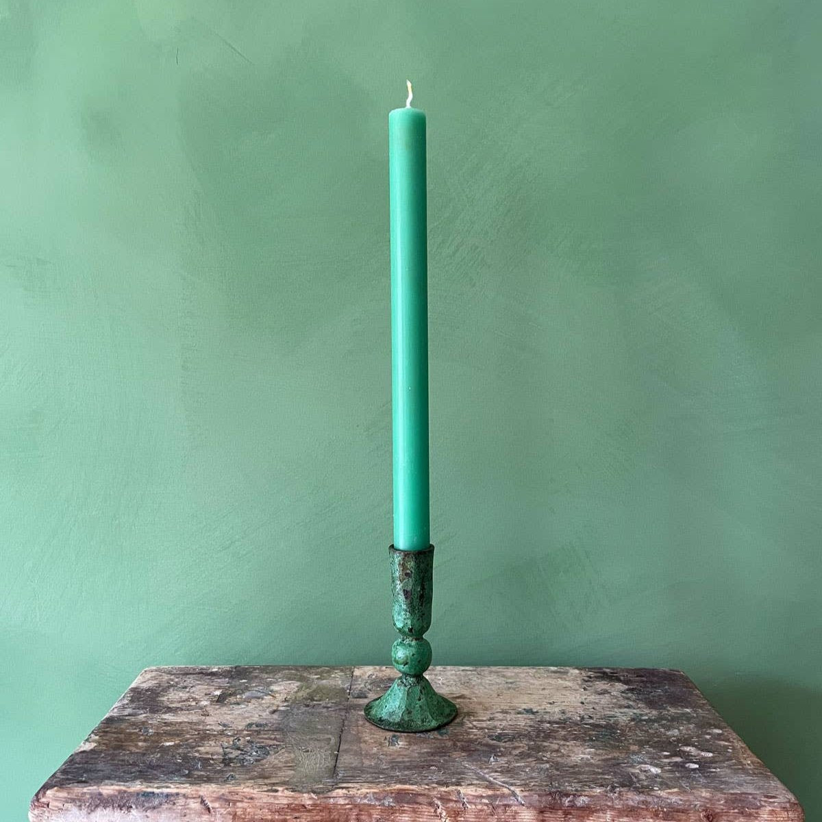 Product shot of Green 100% iron candle holder with green candle to display use 