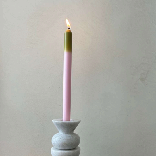 Pygmalion Dinner Candles baby pink with a green tip displayed against a white background in a white ceramic candle holder 