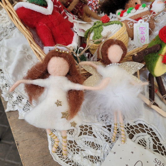 Two angel figurines with brown hair and white dresses, one with gold wings and the other with silver wings, both adorned with polka dots and stars.