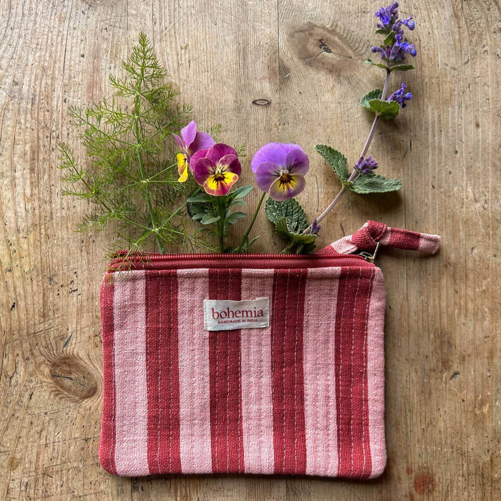 Red and pink striped pouch with flowers on a wooden surface