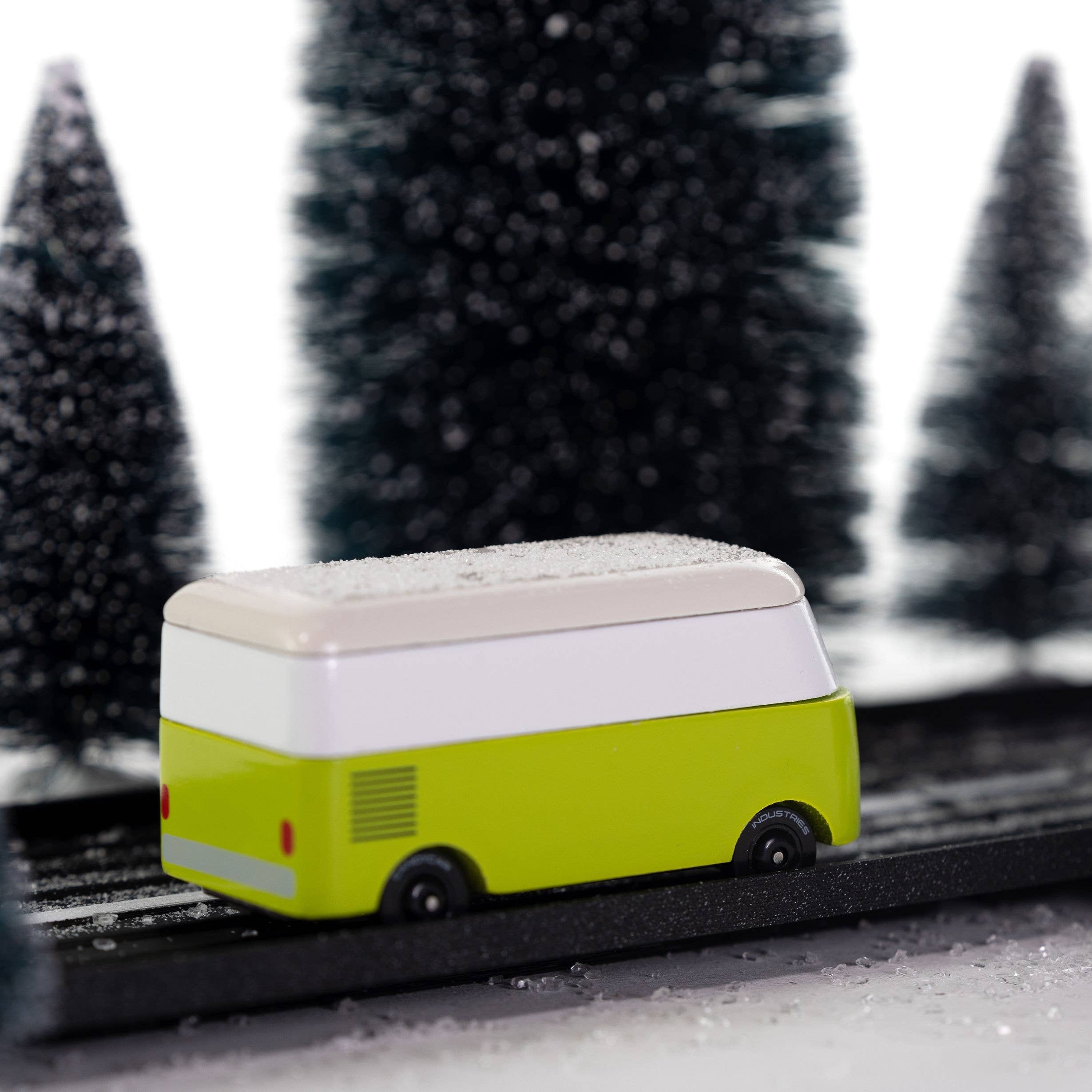 Toy bus on a track with snow-covered trees in the background