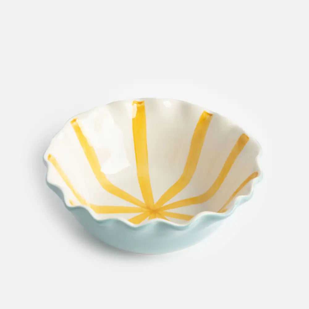 Shell-shaped ceramic dish with yellow interior and light blue exterior on a white background