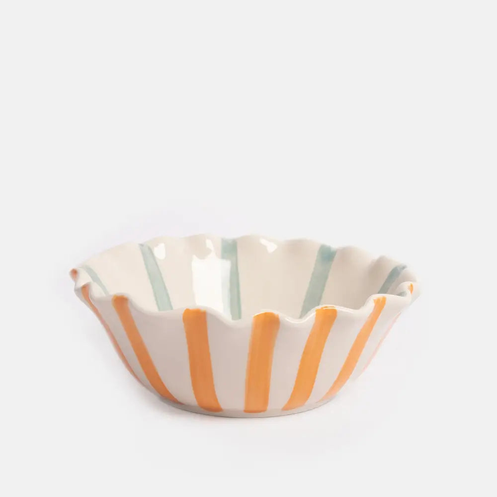 Ceramic bowl with orange and green stripes on a white background