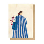 Greeting card with a painting of a person in a blue and white striped dress holding flowers, on a beige background.