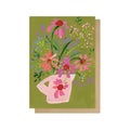 Greeting card with a pink teapot and floral design on a green background