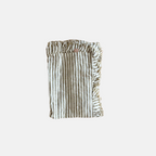 Striped ruffled hem linen table runner on a white background