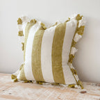 Striped pillow with tassels on a wooden surface