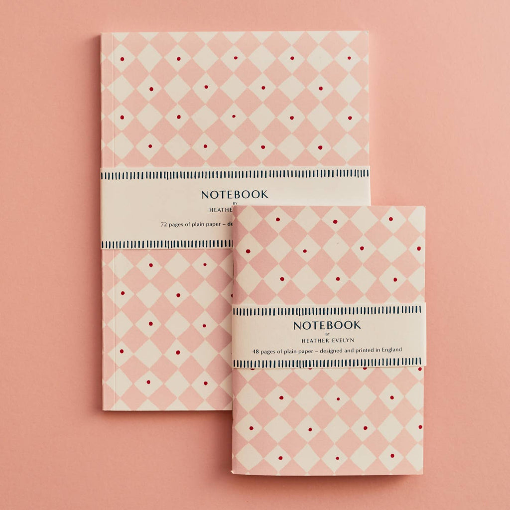 Two notebooks with a geometric pattern on a pink background