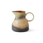 Ceramic milk jug with a speckled design on a white background