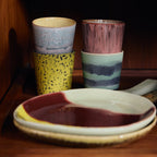 Four ceramic cups with different patterns on a wooden surface