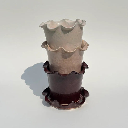 Stack of ceramic planters with ruffled edges on a white background