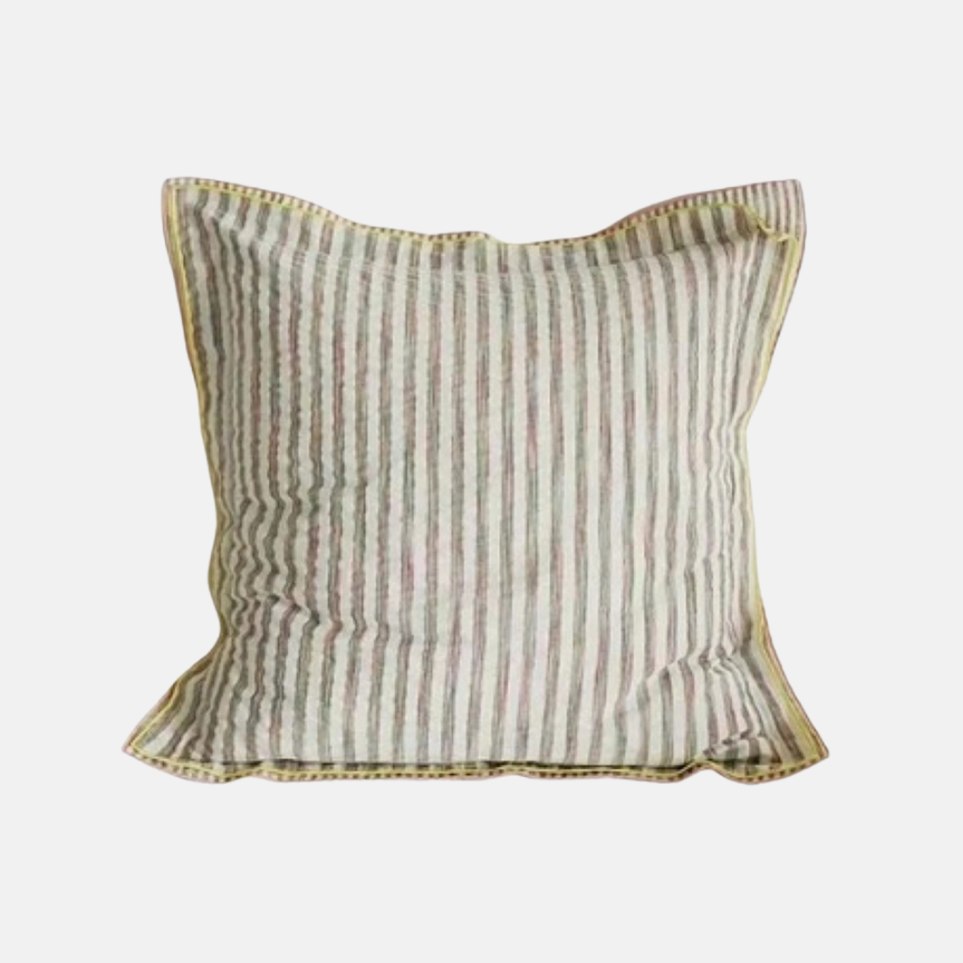 A square decorative throw pillow with vertical stripes in muted beige, olive green, and soft pink, finished with a gold-toned piped edge, shown against a plain light gray background.