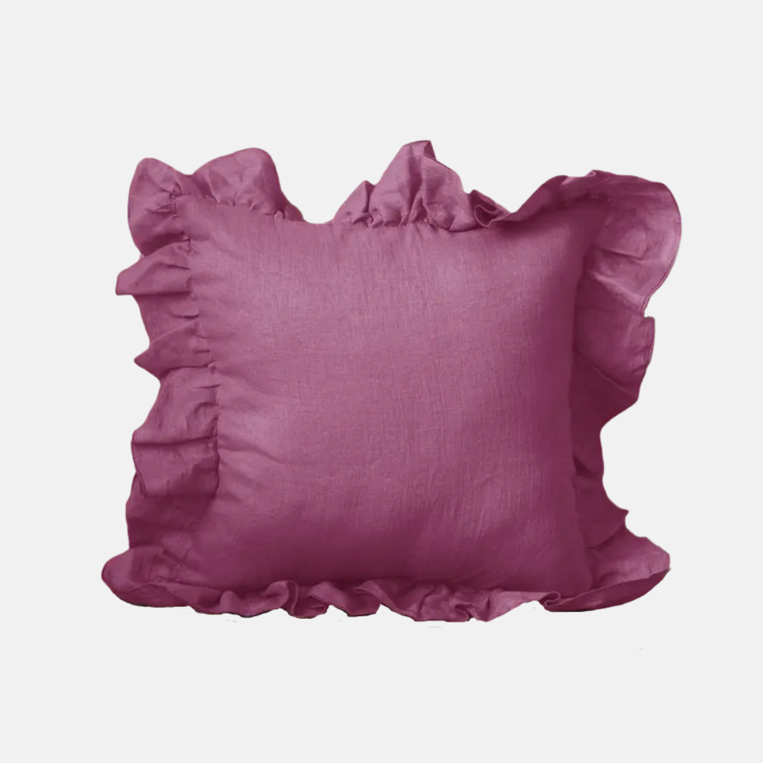 A square decorative throw pillow in a dusty mauve-purple color, featuring a ruffled trim around the edges, shown against a plain light gray background.