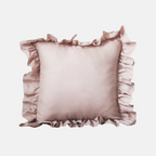 A square decorative throw pillow in a dusty rose pink color, featuring ruffled trim along all four edges, shown against a plain light gray background.