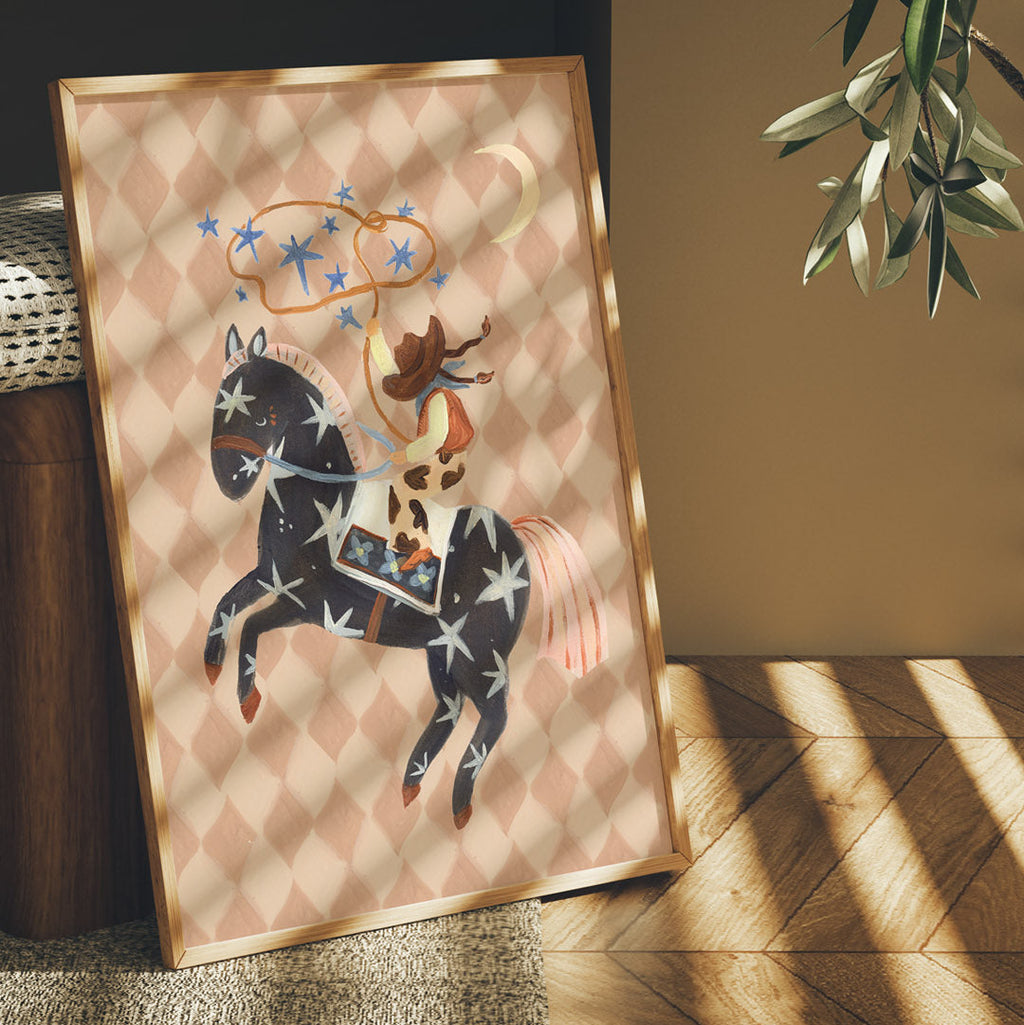 Framed artwork of a horse and rider on a patterned background, placed indoors with natural light.