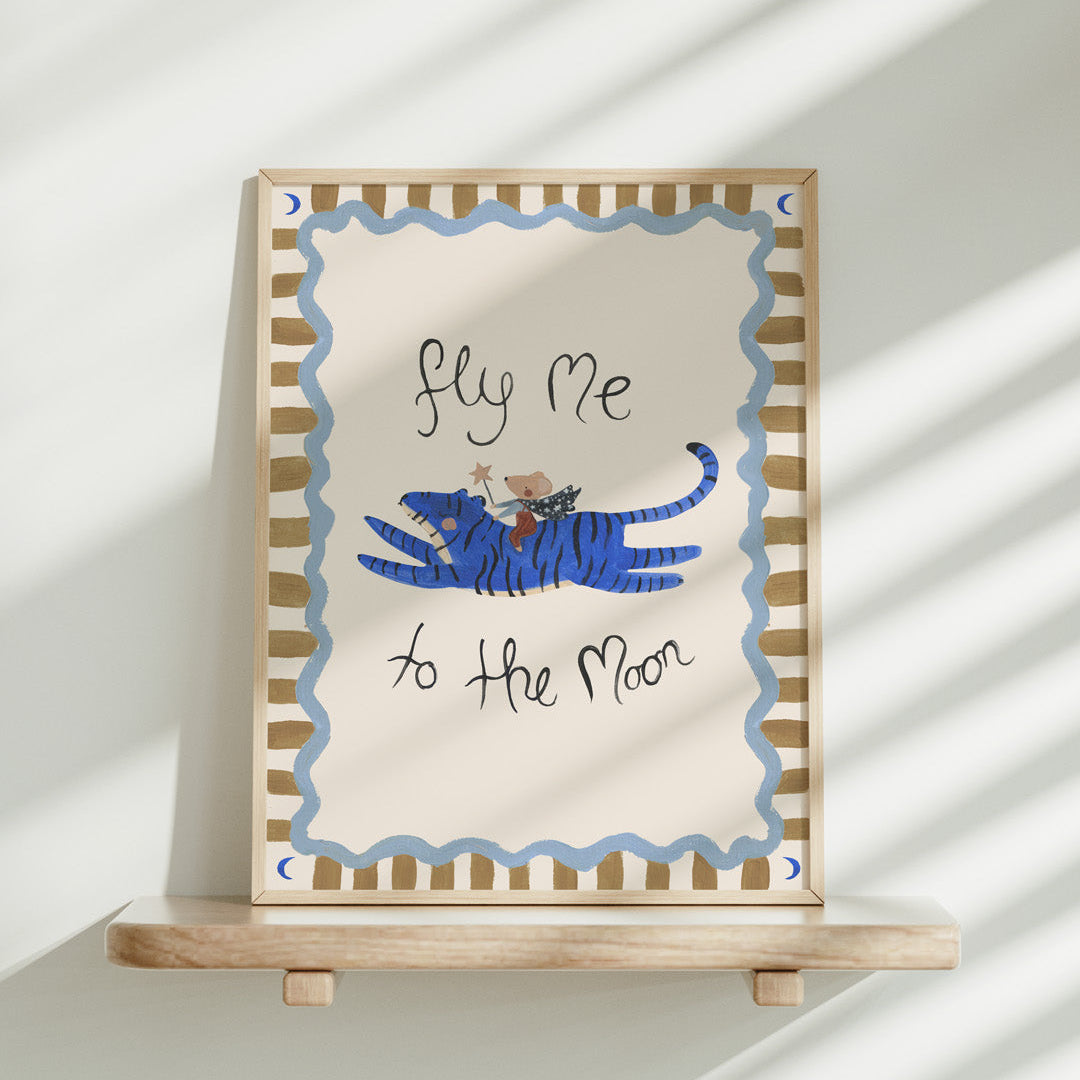Framed artwork with a blue tiger and text 'fly me to the moon' on a white background