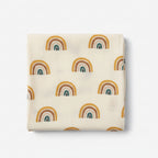 organic cotton baby muslin with rainbow pattern and a cream overall colour displayed hanging 