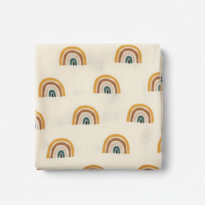 organic cotton baby muslin with rainbow pattern and a cream overall colour displayed hanging 