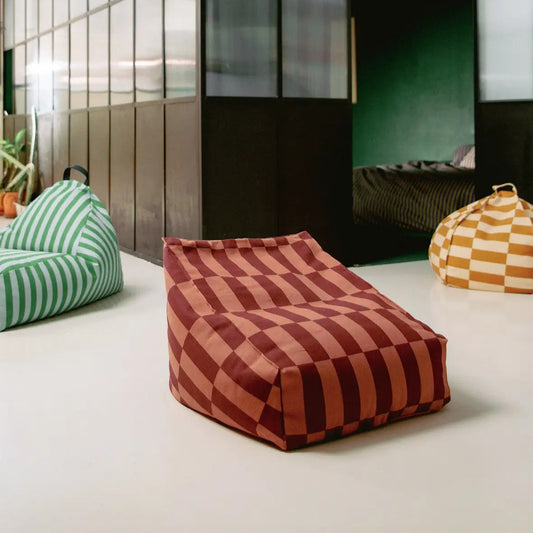Striped bean bags in various colors on a light floor with a modern room background.