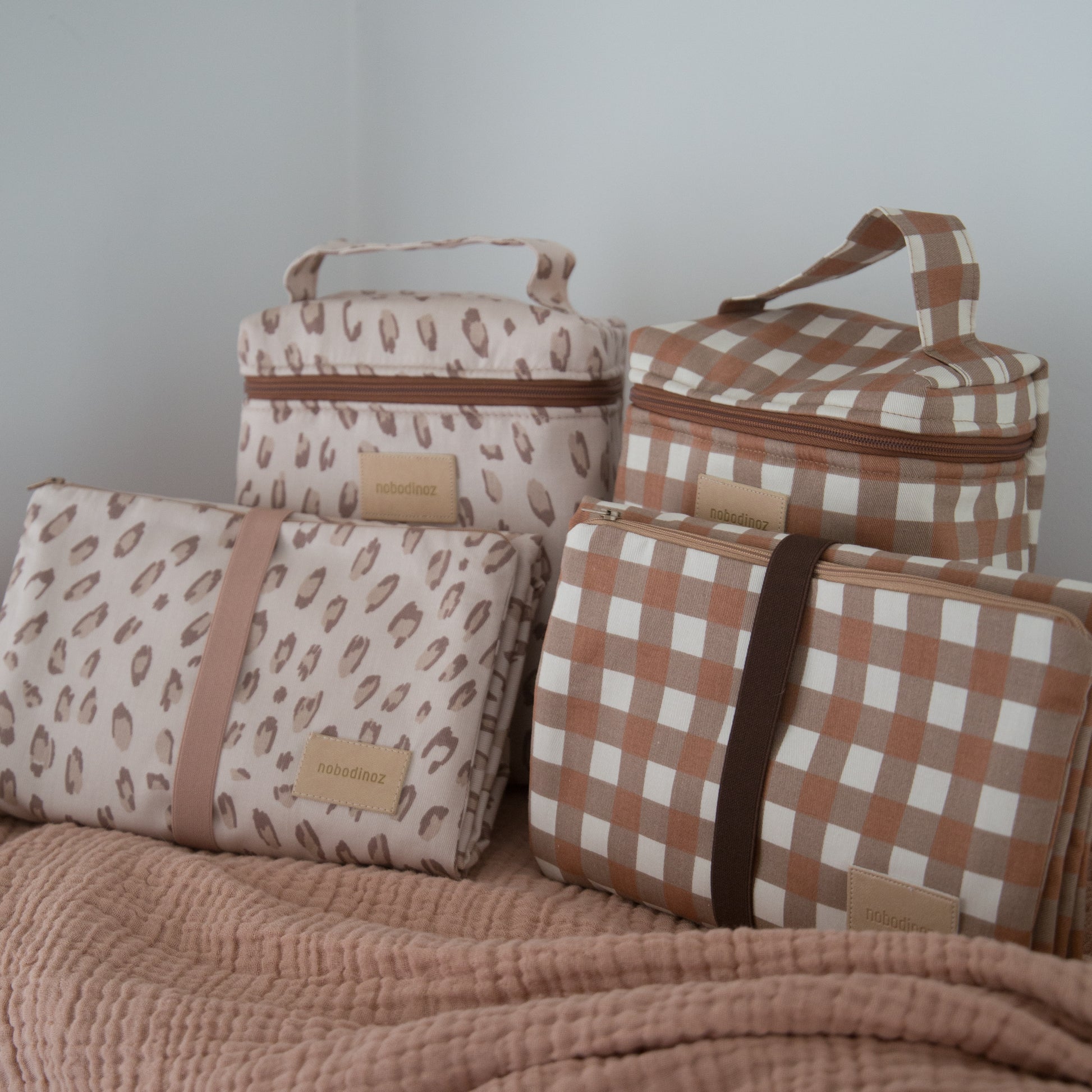 nobodinoz organic cotton baby changing mats displayed with matching bottle bags 